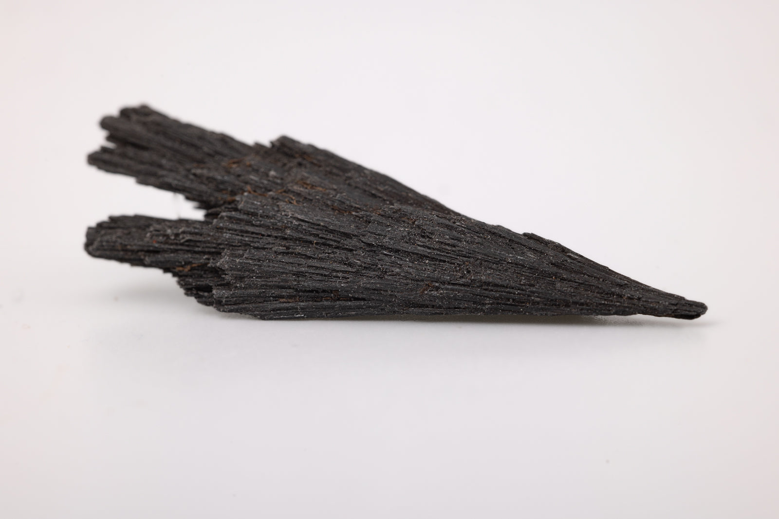 Black Kyanite raw crystals, available in small (1.5") and large (3"+) sizes, handpicked for you by Juniper Stones.