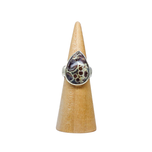 Tear drop-shaped Ocean Jasper ring in size 8. This unique stone combines energies of water and volcanic rock, bringing a blend of fiery and cool energies. Infuses joy, lifts negativity, and promotes tissue regeneration. Pairs well with Amethyst. Heart, Solar Plexus, and Throat Chakra activation. Shop now!